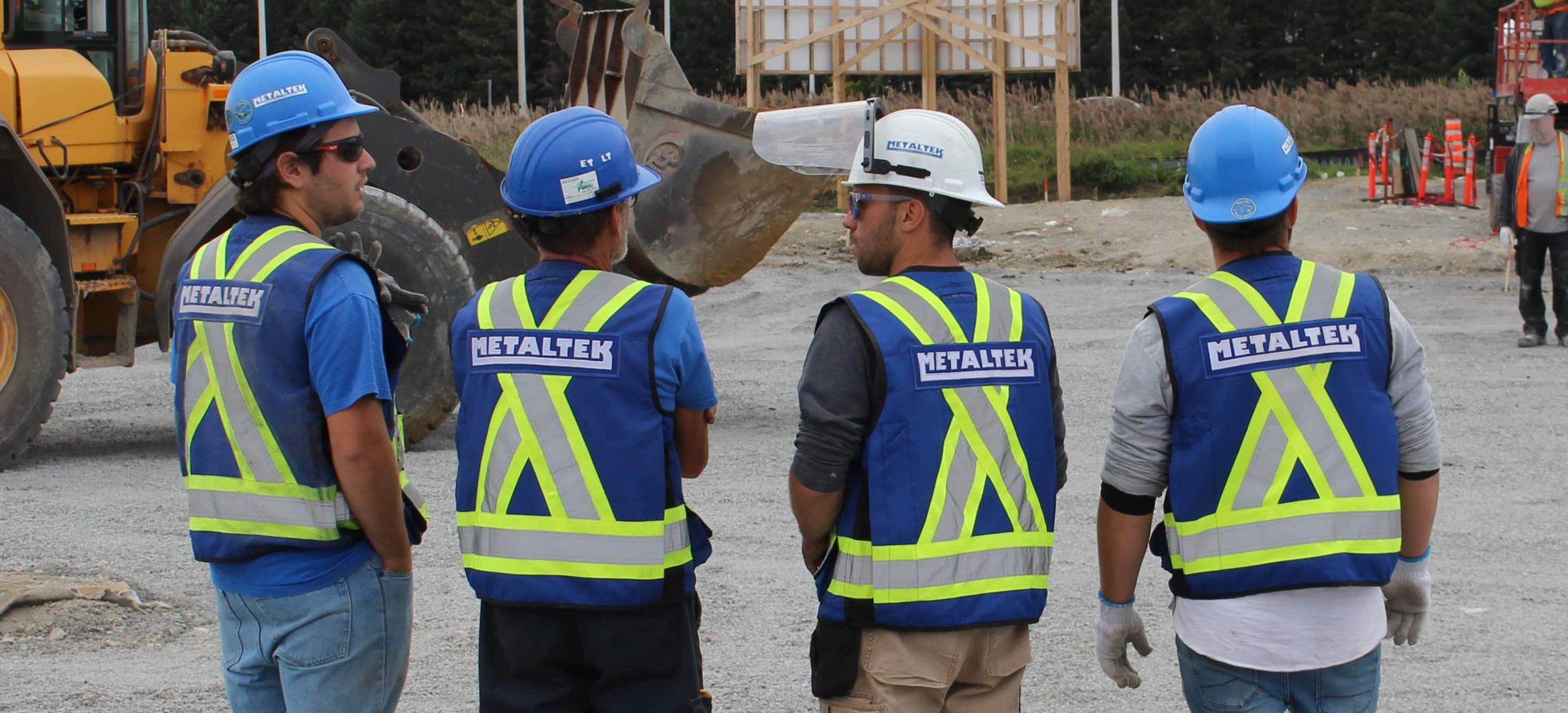 Employés discutant d'un plan sur le chantier.